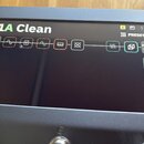 Detailní pohled na displej digitálního efektového procesoru. Na obrazovce je zobrazen preset s názvem 1A Clean a řetězec efektů znázorněný ikonami, z…