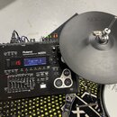 Černý elektronický bicí modul značky Roland s nápisem DRUM SOUND MODULE TD-30 a logem SuperNATURAL. Displej zobrazuje modré pozadí s textem Fusion. M…