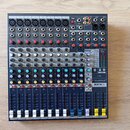 Modrý mixážní pult s šedým ovládacím panelem. Na přístroji jsou vidět nápisy exicon, Soundcraft a model EFX 8. V pravé části je digitální displej s t…