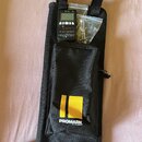 Černý textilní obal s žlutým logem a nápisem PROMARK BY D'ADDARIO. Na obalu je položen černý digitální tuner s nápisy JOYO a JM-T55C Tuner/Metro. Ved…