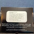 Fotografie zachycuje zadní stranu černé krabice od snímačů. Na krabici je bílá nálepka s textem „R.M.pickups Humbucker Maze Ranks-1“ a popisem v češt…