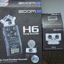 Fotografie zobrazuje dvě krabice od značky ZOOM. Větší krabice obsahuje obraz zařízení s nápisy H6 Handy Recorder a Six-Track Portable Recorder with…