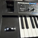 Detailní pohled na ovládací panel a klávesy černé elektronické klávesové nástroje. Na panelu jsou nápisy POWER, DC IN, USB COMPUTER a USB MEMORY u US…