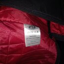 Detail vnitřku černého obalu s červenou prošívanou podšívkou. Na bílé tkané štítku je logo s nápisem RITTER a texty 19.19.15.8, Design & Quality, Rit…