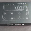 Krabice s černým povrchem, na které je bílý lineární nákres kytarového efektového procesoru. V pravém horním rohu je nápis GE300 Amp modelling & Mult…