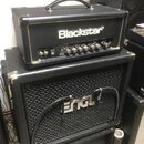 Na fotografii je černý kytarový zesilovač Blackstar umístěný na černém kytarovém kombu značky ENGL. Horní zařízení má bílý nápis Blackstar a označení…