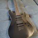 Černá elektrická kytara s trupem v kovovém lesklém provedení a hnědým hmatníkem. Nástroj má dva humbuckery, jeden ovládací knoflík a přepínač snímačů…