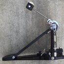 Černý basový pedál s chromovanou tyčí a mechanismem. Na horní části chromovaného kloubu je vidět červenobílý nápis "Gretsch". Povrch černých kovových…