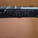 Zadní strana černého MIDI kontroléru s nápisem FRACTAL AUDIO SYSTEMS | MFC-101. Jsou zde viditelné konektory s popisky POWER 9VAC, MIDI OUT, MIDI IN,…