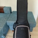 Černý polotvrdý pouzdro na hudební nástroj s texturovaným povrchem. V dolní části je bílý lem a oválný štítek s nápisem MUSIC AREA. Na pravém boku je…