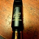 Černý saxofonový munční dutý nástroj s kovovou zlatou patkou. Na povrchu je bílý nápis „Jody Jazz“, pod ním označení „HR*“ a text „CUSTOM DARK“. Na h…