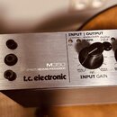 Detailní pohled na přední panel stříbrného efektového procesoru. Na zařízení je uveden nápis M350 EFFECT | REVERB PROCESSOR a logo t.c. electronic. V…