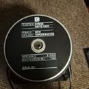 Fotografie zachycuje zadní stranu černého kruhového reproduktoru s bílými nápisy. Na štítku je uvedeno: „CELESTION POWER DRIVE UNIT“, „IPSWICH ENGLAN…