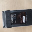 Fotografie zachycuje spodní stranu šedého efektpedálu z plastu nebo kovu. Na černé štítku je bílý nápis BOSS a text: CAN ICES-003(B)/NMB-003(B), UK C…