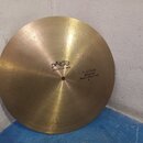 Zlatavý mosazný činel s plochým profilem. Na povrchu je vyraženo logo paiste a nápis FORMULA 602. Vedle otvoru se nachází text FLAT RIDE MEDIUM Seven…