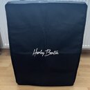 Černý textilní kryt na hudební zařízení s obdélníkovým tvarem. V dolní polovině je bílý nápis Harley Benton. Povrch materiálu vykazuje mírné pomačkán…