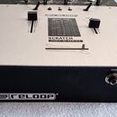Černý elektronický přístroj s hliníkovým horním panelem. Na panelu je nápis SCRATCH HIGH-Q-SERIES, tabulka OUTPUT LEVEL pro CH-1 a CH-2 a dva posuvní…