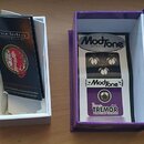 Fotografie zobrazuje efekt Tremolo v fialovém krabičce s bílým vnitřkem. Na pedálu je nápis ModTone effects, dále ModTone a v dolní části TREMOR s me…