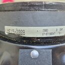 Detailní pohled na zadní část černého reproduktoru. Na šasi je nalepený bílý papírový štítek s nápisy MF15-2008, 15903, 8 OHM a 67-97190347 G1. Povrc…