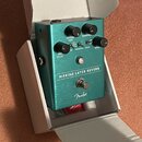 Tyrkysový efekt pedál s kovovým povrchem v kartonové krabici. Na přední straně je nápis MARINE LAYER REVERB a logo Fender. Pedál má čtyři ovládací kn…
