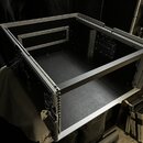 Černý transportní case s hliníkovými hranami a profilem. Vnitřní prostor je vyložen černým materiálem a obsahuje hliníkové lišty pro montáž zařízení.…