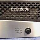 Detailní pohled na přední panel černého zařízení s kovovou mřížkou a stříbrným spodním panelem. Na mřížce je nápis CTs 2000. Stříbrný panel obsahuje…
