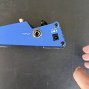 Modrý efekt pedál s kovovým povrchem. Na boku jsou viditelné nápisy INPUT a DC 9V spolu s ikonou polarity. Jsou zde dva konektory, jeden pro vstup si…