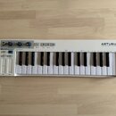 Bílá klaviatura s 32 klávesami. Na pravé straně je nápis ARTURIA a pod ním slogan YOUR EXPERIENCE YOUR SOUND, vlevo je označení KEYSTEP. Horní panel…