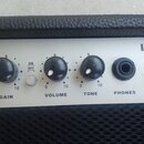 Detail ovládacího panelu kytarového komba v bílé barvě. Na panelu je nápis REEF AUDIO a označení modelu LA5. Jsou zde ovládací prvky s popisky INPUT,…
