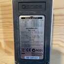 Zadní strana efektového pedálu značky BOSS v černém plastovém provedení s kovovým rámem. Na spodní části je nalepený štítek s nápisy BOSS AC ADAPTOR,…