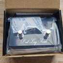 V kartonové krabici v plastovém obalu je umístěn černý kytarový efekt s nápisem Dual Loop Switch. Zařízení má dva kovové spínače a jeden červený kont…