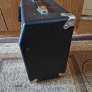 Černý kytarový kombozesilovač s povrchem z texturovaného vinylu. Na horní straně je umístena kovová rukojeť a v zadním rohu stříbrný kovový roh. Na b…