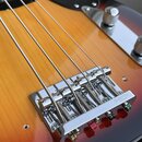Detailní záběr na chromovaný kobylník elektrické basové kytary s tělem v barevnosti sunburst. Na pravém boku kobylníku je vyryt nápis GOTOH JAPAN. Ná…