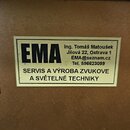 Fotografie detailu hnědého povrchu s nalepenou obdélníkovou nálepkou. Na nálepce je vlevo výrazný černý nápis EMA a vpravo text Ing. Tomáš Matoušek,…
