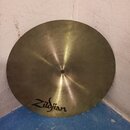 Kruhový mosazný činel s viditelným broušením povrchu. V dolní části je černý nápis Zildjian. Povrch vykazuje drobné škrábance a známky používání.