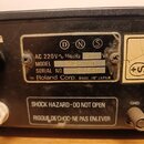 Detail zadní strany černého elektronického zařízení s několika štítky. Na hlavním černém štítku je uveden nápis AC 220V ~ 50/60Hz 500 VA, MODEL SPA-1…