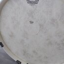 Bílá vyztužená kože v rámci obruče. V horní části je logo REMO a nápis POWERSTROKE® PJ FIBERSKYN®3 FA MADE IN U.S.A. V centru je nalepený kruhový ští…