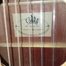Detail vnitřku akustické kytary s viditelnou štítkem na dřevěném povrchu. Na štítku je logo COBRA, nápis Acoustic guitar a Model No. BW-414CE N. Dole…