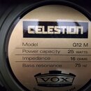 Detailní pohled na zadní štít reproduktoru v olivově zeleném rámu. Na štítku je uvedeno logo CELESTION a specifikace: Model G12 M, Power capacity 25…