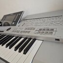 Stříbrný digitální klavír s klávesnicí. Na horním panelu je nápis DIGITAL WORKSTATION a modelové označení TYROS 4. Nástroj obsahuje displej, zahlreic…