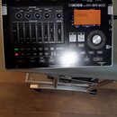 Černý digitální nahrávací zařízení s nápisem BOSS DIGITAL RECORDER BR-800. Přístroj obsahuje displej, několik posuvníků track mixeru, ovládací knoflí…