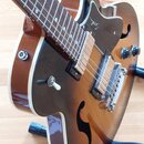 Polodupatá elektrická kytara s hnědým sunburst povrchem a bílým lemováním. Na hmatníku je vidět vložka s čísly 1 až 5 a na pickguardu je nápis Godin.…