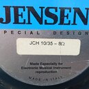 Detailní záběr na štítku reproduktoru. Na modrém pozadí je černý nápis JENSEN a pod ním text SPECIAL DESIGN. Na bílé nálepce je uvedeno JCH 10/35 – 8…