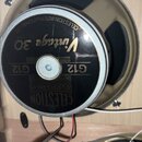 Fotografie zachycuje zadní stranu reproduktoru. Na černém krytu s kovovým okrajem jsou zlatým a bílým písmem nápisy CELESTION INTERNATIONAL LTD., Vin…