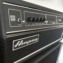 Černý basový zesilovač s kovovými listy. Na předním panelu je logo Ampeg, vstup Input, tlačítka Pad a Peak s červenou kontrolkou a šesti otočnými kno…
