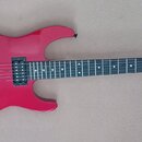 Červená elektrická kytara s tmavým hnedým hmatníkem a černým hardwarem. Na hlavě je bílý nápis Jackson. Nástroj má dva humbuckery, jeden snímač typu…
