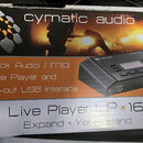 Fotografie znázorňuje krabici od zařízení s nápisem cymatic audio. Na obalu je zobrazen černý přístroj a texty 16-track Audio / MIDI Live Player and…