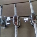 Tři chromované ladicí mechanismy s kovovými knoflíky s křížovým rýhováním. Povrch je lesklý a vykazuje drobné odrazové nečistoty. Žádné značky ani ná…