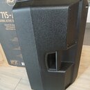 Černý aktivní reproduktor z plastového materiálu s texturovaným povrchem. Na pozadí je vidět kartonová krabice s logem RCF a nápisy 715-A, IONAL ACTI…