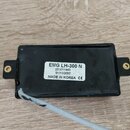 Černý elektrický snímač s dvěma montážními uchyty po stranách. Na spodní straně je bílá nálepka s nápisy EMG LH-300 N, (21)011440, 01/10/2007 a MADE…